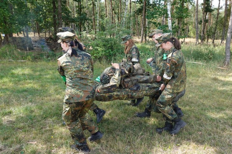 Bild 5: Transport eines Verletzten im Rahmen der Selbst- und Kameradenhilfe, mit der zuvor selbst gebauten Trage. (Foto: Bundeswehr/Dörr)